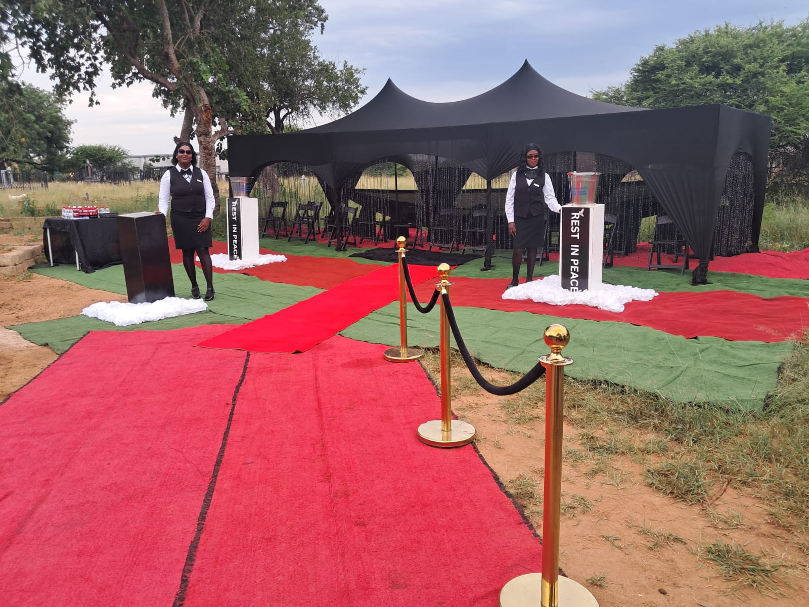 Graveside tent with red carpet aisle and Corbis Trading ushers on duty