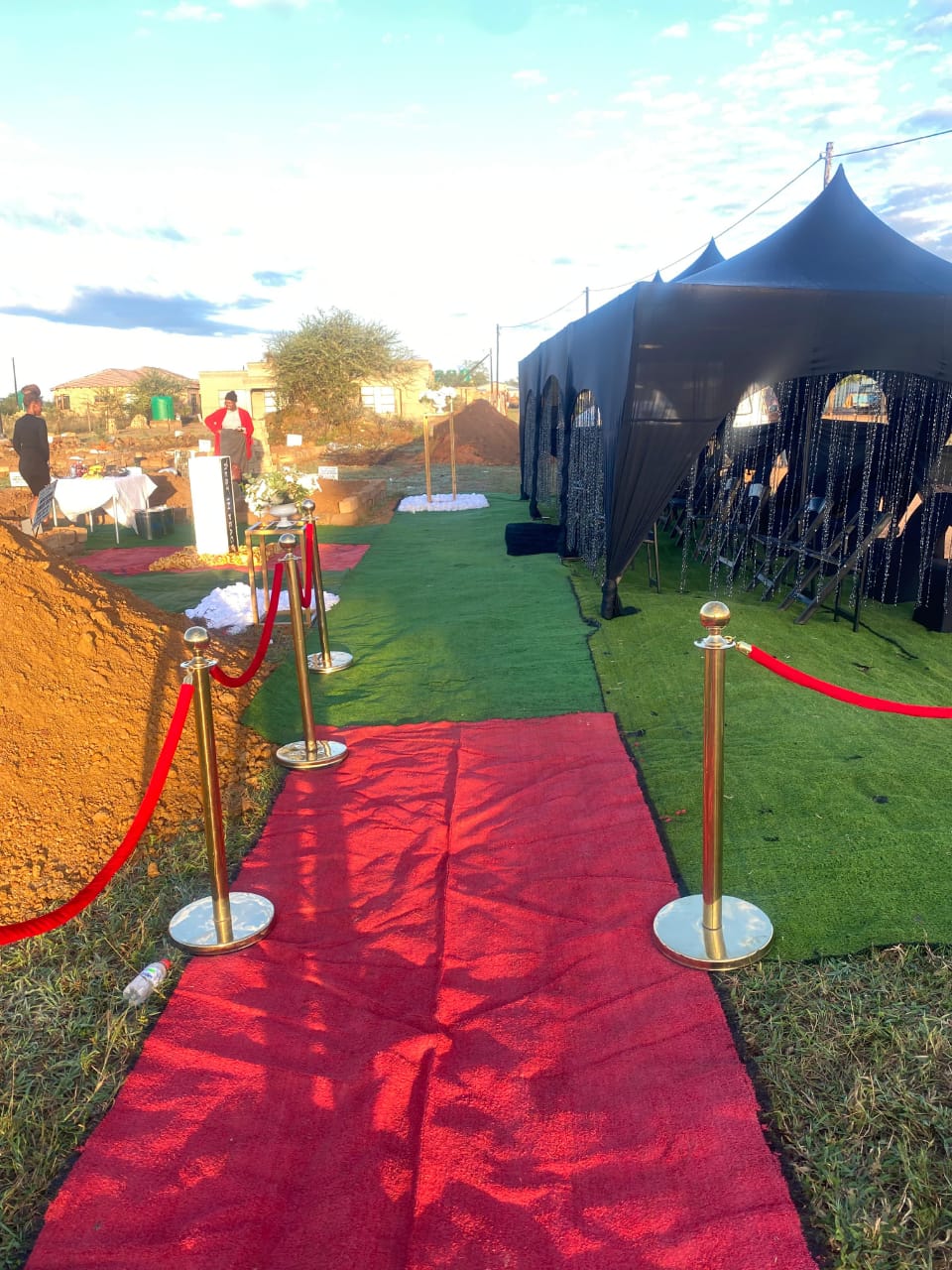 Red carpet walkway leading to a graveside tent